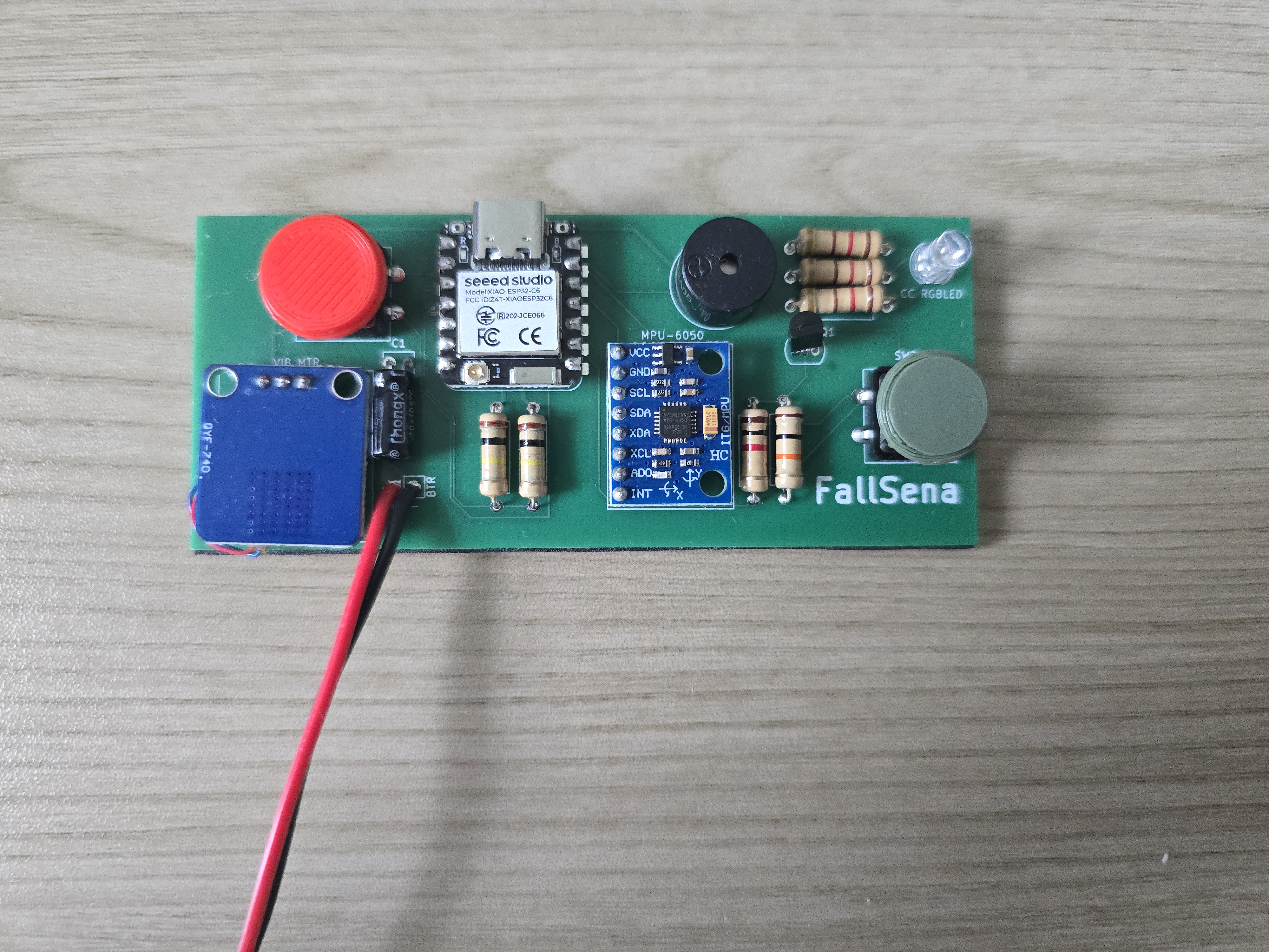 The FallSena board with its parts soldered on, including the ESP32-C6 module, the MPU6050 sensor, a red and a grey button, and red and black battery leads